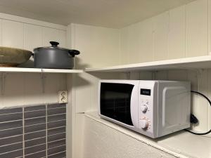 a white microwave on a counter in a kitchen at Fantastic Apartment Tromsø Two in Tromsø
