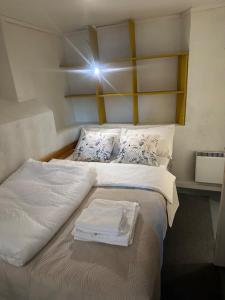 a bed with two white towels on top of it at Fantastic Apartment Tromsø Two in Tromsø