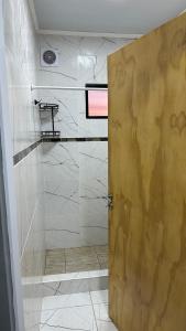 a bathroom with a shower with a wooden door at Lo de jota in Ramallo +4 photos