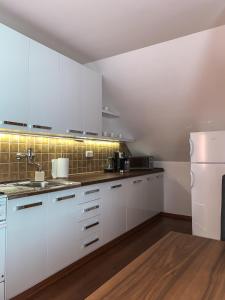 a kitchen with white cabinets and a white refrigerator at Apartmánový dom Adriana in Zuberec