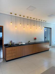 a kitchen with a counter with lights above it at Rosmarry Hotel in Colinas do Tocantins