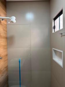 a bathroom with a glass shower with a blue stick at Rosmarry Hotel in Colinas do Tocantins +12 photos