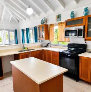 a kitchen with wooden cabinets and a black appliance at Willis staycation in Sandy Bay