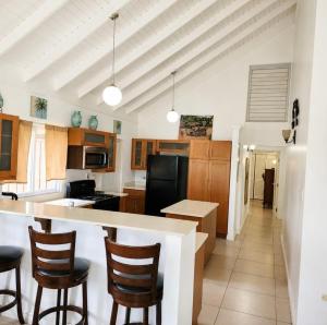 a kitchen with a counter and some chairs in it at Willis staycation in Sandy Bay