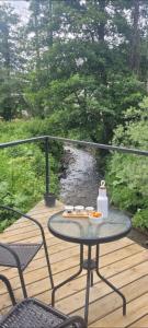 a table and chairs on a deck with a view of a river at Greenfield Bakuriani, Mountain Villas & Homes in Bakuriani
