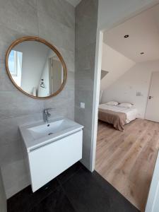 a bathroom with a sink and a mirror and a bed at Villa Danni in Quiberon
