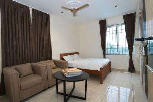 a living room with a couch and a bed at Shree Priyam Residency in Rāmanāthapuram