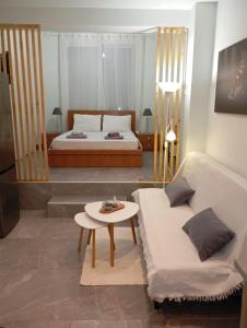 ein Wohnzimmer mit einem Bett und einem Tisch in der Unterkunft Studio Ariadne in Thérmi