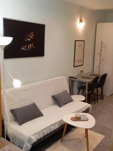 ein Wohnzimmer mit einem weißen Sofa und einem Tisch in der Unterkunft Studio Ariadne in Thérmi