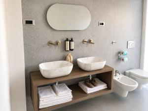 a bathroom with two sinks and a mirror at Amaurusa Boutique Hotel in Taormina