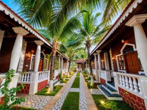 a courtyard of a house with palm trees at Palm Escape Beach Resort in Baga
