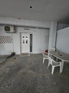 a room with a table and chairs and a door at Aspa's house in Athens