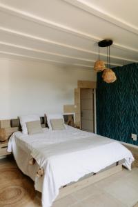 a bedroom with a large bed with white sheets at Le Domaine des peupliers in Saint-Germain-du-Seudre