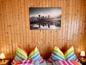 a wooden wall with a picture above a couch with pillows at Chalet Alpenheim 1 OG in Bettmeralp