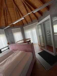 a bedroom with a large bed in a room with windows at Auszeit am Dankernsee in Altharen