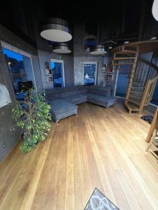 a living room with a couch and a wooden floor at Auszeit am Dankernsee in Altharen