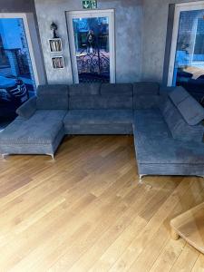 a large couch in a living room with a wooden floor at Auszeit am Dankernsee in Altharen +12 photos