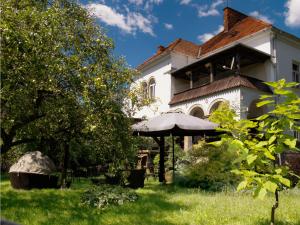 a large white house with an umbrella in the yard at Willa Wiluszówka in Dębica