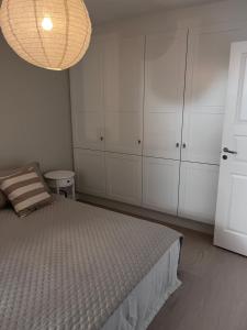 a bedroom with a bed and white cabinets and a chandelier at Fjallbacka, Modern nyproducerad lägenhet med egen parkering och laddning in Fjällbacka