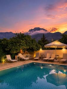 a swimming pool with chairs and an umbrella at The Selection Butik Otel in Kemer