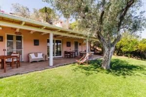 a house with a deck with a tree at B&B Kapì Country in Alghero