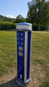 ein blau-weißer Verkaufsautomat auf einem Feld in der Unterkunft Ausee Camping in Blindenmarkt + 2 Fotos