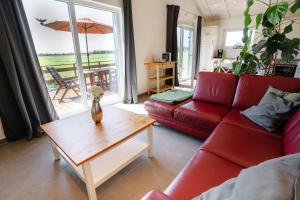 a living room with a red couch and a coffee table at Haus Freija in Sehestedt