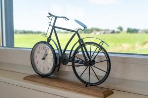 a clock sitting on a window sill next to a bike at Haus Freija in Sehestedt