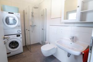 a bathroom with a washing machine and a sink at Haus Freija in Sehestedt +34 photos