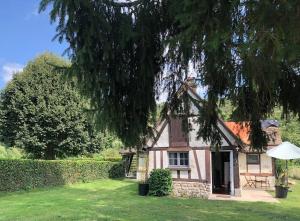 a small pink house with a tree at Maison du Verger in Brosville