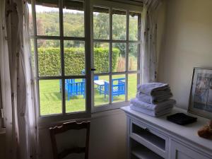 a stack of towels sitting on a table in front of a window at Maison du Verger in Brosville