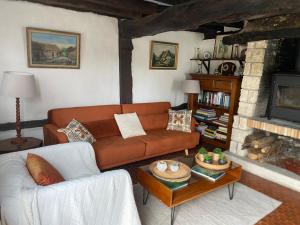 a living room with a couch and a fireplace at Maison du Verger in Brosville