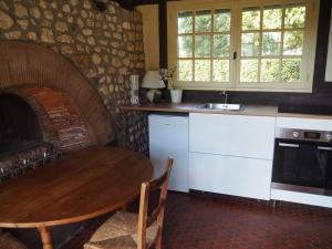 a kitchen with a table and a kitchen with a fireplace at Maison du Verger in Brosville