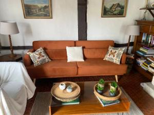 a living room with a couch and a table at Maison du Verger in Brosville +7 photos