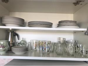 a shelf with plates and glasses and dishes on it at Апартаменты Vilada in Zatoka +12 photos
