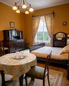 a bedroom with two beds and a table with chairs at Willa Wiluszówka in Dębica