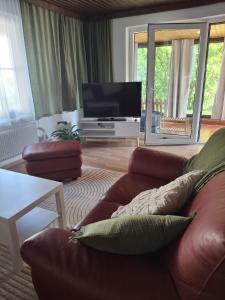 a living room with a couch and a flat screen tv at Ferienwohnung Edith-Maria in Bad Goisern