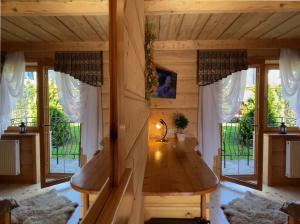 a room with a wooden table in a cabin with windows at Pensjonat u Ani in Zakopane