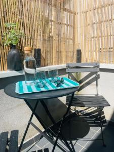 a table with a vase and glasses on it next to a chair at Studio Ô terrasses de Virieu in Pélussin +5 photos