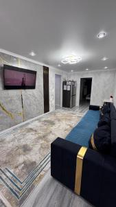 a living room with a couch and a flat screen tv at Квартира посуточно in Balqash