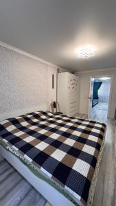a bedroom with a black and white checkered bed at Квартира посуточно in Balqash