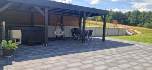 a pavilion with a table and chairs on a patio at Dom Na Chwilę in Brzozowa