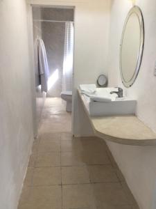 a white bathroom with a sink and a mirror at Paz y Mar in Chelem +1 photo