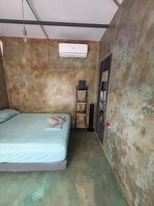 a small room with a bed and a ladder at Green TinyHome 1 in Uvita
