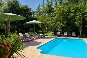 a swimming pool with chairs and umbrellas next to at Mas Ferrer by 123ole in Sant Andreu del Terri