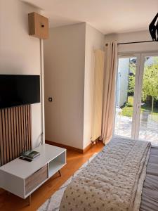 a bedroom with a bed and a desk and a television at Orée de Villevert in Senlis