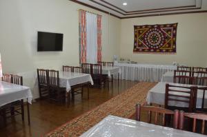 a dining room with tables and chairs and a tv at Hostel East Star Khiva in Khiva