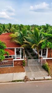 a house with palm trees in front of a street at Palm Escape Beach Resort in Baga +17 photos