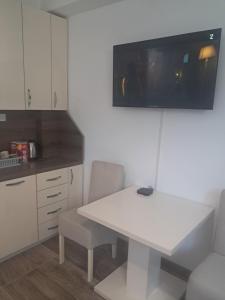 a white kitchen with a white table and chairs at Apartment Nikola R in Žabljak +2 photos