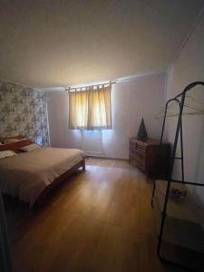 a bedroom with a bed and a dresser and a window at Belle vue étoilée in Saint-Ouen